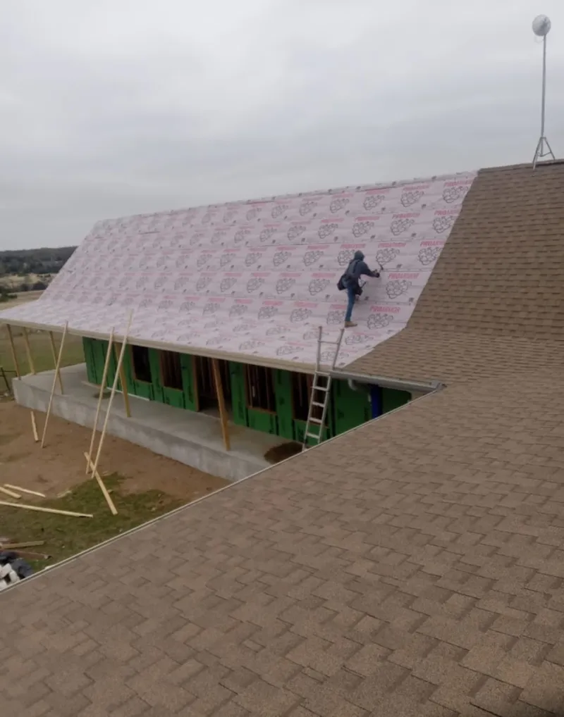 Worker preparing underlayment for a metal roof installation in Los Ranchos de Albuquerque